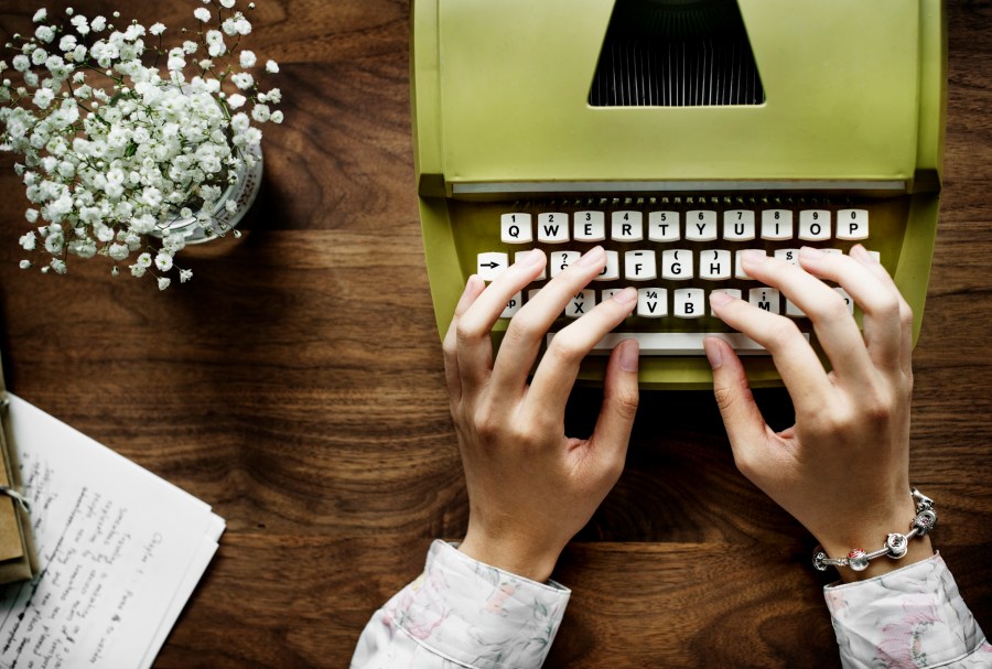 Aerial view a woman using a retro typewriter